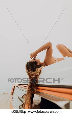Young woman in bikini lying on top of recreational vehicle at beach, Jalama, California, USA View Large Photo Image Stock Photography - Young woman in bikini lying on top of recreational vehicle at beach, Jalama, California, USA. Fotosearch