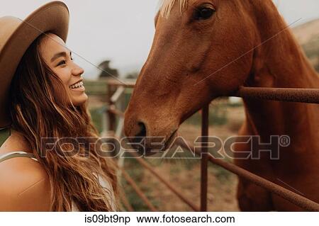 Young woman in felt hat face to face with horse, Jalama, California, USA View Large Photo Image Stock Photography - Young woman in felt hat face to face with horse, Jalama, California, USA. Fotosearch