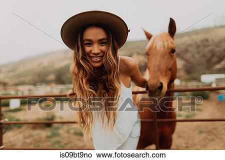 Young woman in felt hat in front of horse, portrait, Jalama, California, USA View Large Photo Image Picture - Young woman in felt hat in front of horse, portrait, Jalama, California, USA. Fotosearch