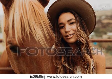 Young woman in felt hat next to horse, close up portrait, Jalama, California, USA View Large Photo Image Stock Image - Young woman in felt hat next to horse, close up portrait, Jalama, California, USA. Fotosearch