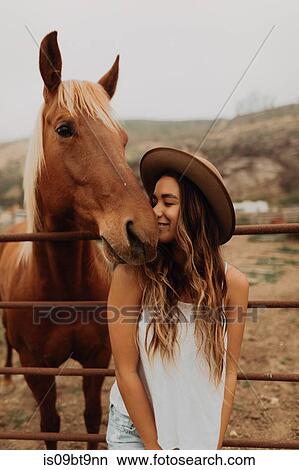 Young woman in felt hat nose to nose with horse, Jalama, California, USA View Large Photo Image Picture - Young woman in felt hat nose to nose with horse, Jalama, California, USA. Fotosearch