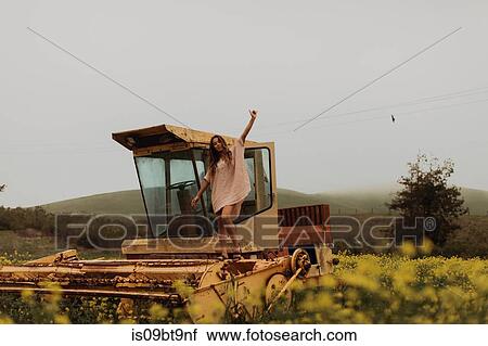 Young woman in field of yellow wildflowers standing on top of abandoned combine harvester, portrait, Jalama, California, USA View Large Photo Image Stock Image - Young woman in field of yellow wildflowers standing on top of abandoned combine harvester, portrait, Jalama, California, USA. Fotosearch