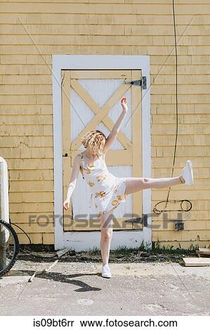 Young woman in front of building kicking her leg up, Menemsha, Martha's Vineyard, Massachusetts, USA View Large Photo Image Stock Photography - Young woman in front of building kicking her leg up, Menemsha, Martha's Vineyard, Massachusetts, USA. Fotosearch