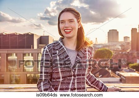 Young woman in front of skyline at roof party in London, UK View Large Photo Image Stock Photograph - Young woman in front of skyline at roof party in London, UK. Fotosearch
