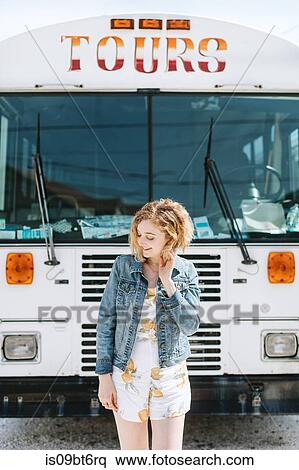Stock Photography - Young woman in front of tour bus, Menemsha, Martha's Vineyard, Massachusetts, USA. Fotosearch