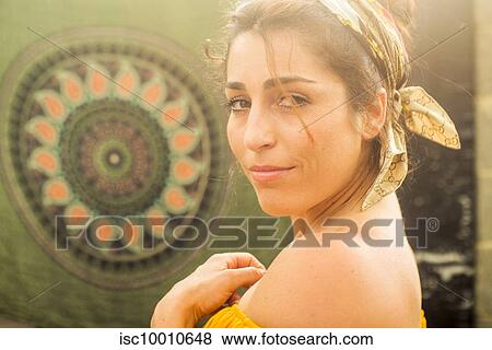 Young woman in headscarf looking over her shoulder at community garden party, head and shoulders portrait View Large Photo Image Stock Photo - Young woman in headscarf looking over her shoulder at community garden party, head and shoulders portrait. Fotosearch
