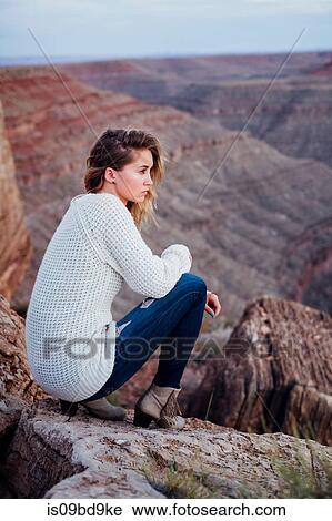 Young woman in remote setting, sitting on rocks, looking at view, Mexican Hat, Utah, USA View Large Photo Image Stock Image - Young woman in remote setting, sitting on rocks, looking at view, Mexican Hat, Utah, USA. Fotosearch