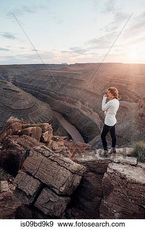 Young woman in remote setting, standing on rocks, looking at view, Mexican Hat, Utah, USA View Large Photo Image Stock Photo - Young woman in remote setting, standing on rocks, looking at view, Mexican Hat, Utah, USA. Fotosearch