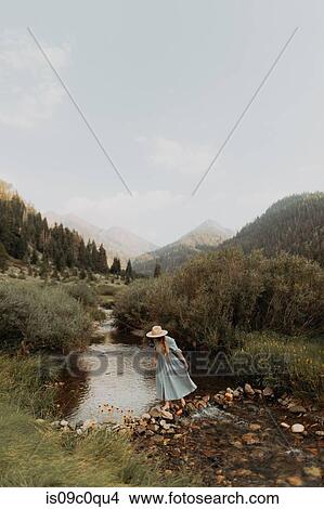 Young woman in stetson crossing stepping stones in rural river, Mineral King, California, USA View Large Photo Image Picture - Young woman in stetson crossing stepping stones in rural river, Mineral King, California, USA. Fotosearch