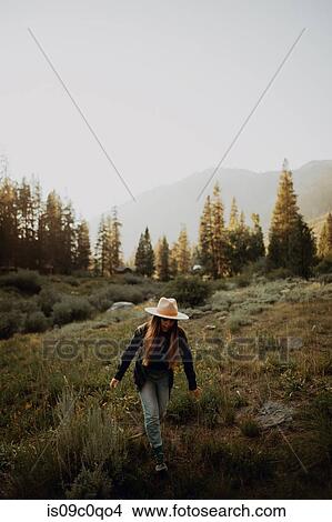 Picture - Young woman in stetson walking in rural valley, Mineral King, California, USA. Fotosearch