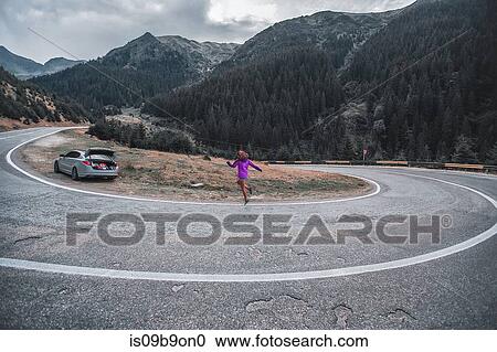Young Woman Jumping On Mountain Road With Hairpin Bend Draja