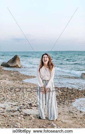 Stock Photo - Young woman laughing on beach, portrait, Menemsha, Martha's Vineyard, Massachusetts, USA. Fotosearch