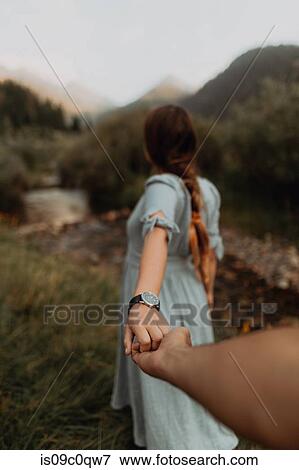 Stock Photo - Young woman leading boyfriend by hand at rural river, Mineral King, California, USA. Fotosearch
