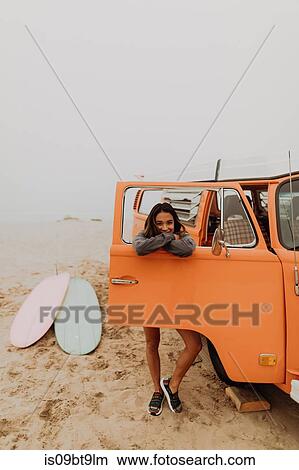 Young woman leaning on recreational vehicle window at beach, portrait, Jalama, California, USA View Large Photo Image Picture - Young woman leaning on recreational vehicle window at beach, portrait, Jalama, California, USA. Fotosearch
