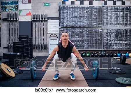 Young woman lifting barbell in gym View Large Photo Image Stock Photo - Young woman lifting barbell in gym. Fotosearch