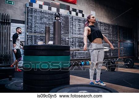 Young woman lifting weight bar in gym View Large Photo Image Stock Photography - Young woman lifting weight bar in gym. Fotosearch