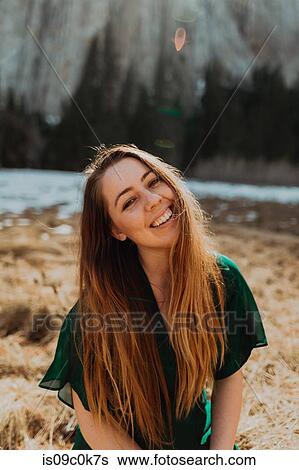 Stock Photograph - Young woman long brown hair by river, portrait, Yosemite Village, California, USA. Fotosearch