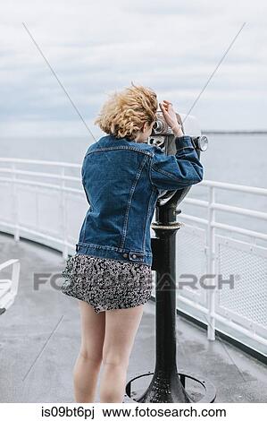 Young woman looking out to sea through coin operated binoculars, Menemsha, Martha's Vineyard, Massachusetts, USA View Large Photo Image Stock Image - Young woman looking out to sea through coin operated binoculars, Menemsha, Martha's Vineyard, Massachusetts, USA. Fotosearch
