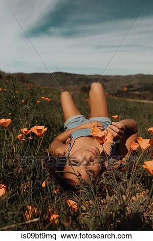 Young woman lying in field of wildflowers, portrait, Jalama, California, USA View Large Photo Image Stock Photography - Young woman lying in field of wildflowers, portrait, Jalama, California, USA. Fotosearch