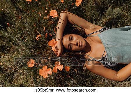 Young woman lying in field of wildflowers, overhead portrait, Jalama, California, USA View Large Photo Image Stock Photography - Young woman lying in field of wildflowers, overhead portrait, Jalama, California, USA. Fotosearch
