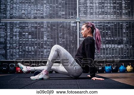 Young woman massaging calf with foam roller in gym View Large Photo Image Stock Photo - Young woman massaging calf with foam roller in gym. Fotosearch