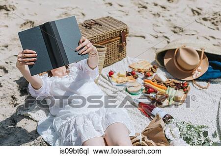 Young woman on picnic blanket at beach reading book, Menemsha, Martha's Vineyard, Massachusetts, USA View Large Photo Image Stock Image - Young woman on picnic blanket at beach reading book, Menemsha, Martha's Vineyard, Massachusetts, USA. Fotosearch