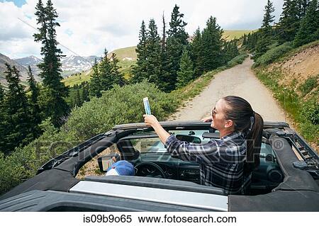 Young woman on road trip taking smartphone selfie travelling in convertible, Breckenridge, Colorado, USA View Large Photo Image Stock Photography - Young woman on road trip taking smartphone selfie travelling in convertible, Breckenridge, Colorado, USA. Fotosearch