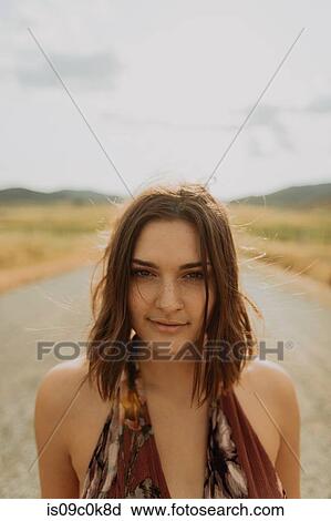 Stock Image - Young woman on rural road, head and shoulder portrait, Exeter, California, USA. Fotosearch