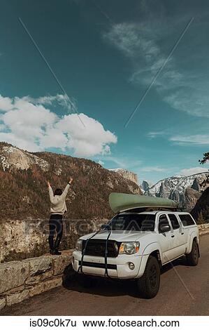 Young woman on top of roadside wall with hands raised, rear view, Yosemite Village, California, USA View Large Photo Image Stock Photograph - Young woman on top of roadside wall with hands raised, rear view, Yosemite Village, California, USA. Fotosearch