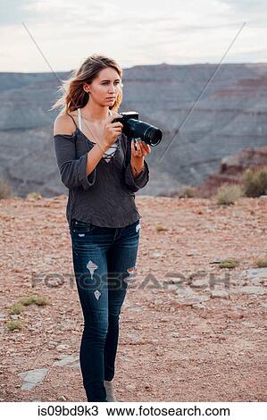 Young woman outdoors, holding SLR camera, photographing surroundings, Mexican Hat, Utah, USA View Large Photo Image Stock Image - Young woman outdoors, holding SLR camera, photographing surroundings, Mexican Hat, Utah, USA. Fotosearch