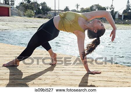 Young woman outdoors, in yoga position, Long Beach, California, USA View Large Photo Image Stock Photo - Young woman outdoors, in yoga position, Long Beach, California, USA. Fotosearch