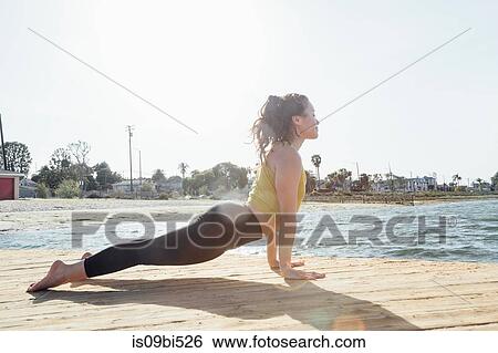 Young woman outdoors, in yoga position, Long Beach, California, USA View Large Photo Image Stock Photograph - Young woman outdoors, in yoga position, Long Beach, California, USA. Fotosearch
