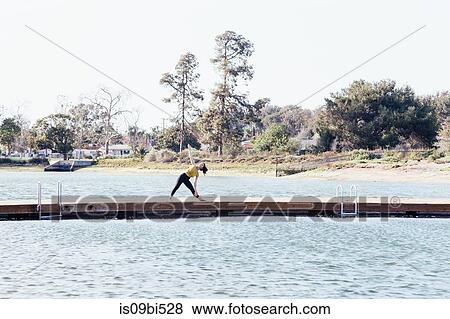 Young woman outdoors, on pier, in yoga position, Long Beach, California, USA View Large Photo Image Stock Photo - Young woman outdoors, on pier, in yoga position, Long Beach, California, USA. Fotosearch
