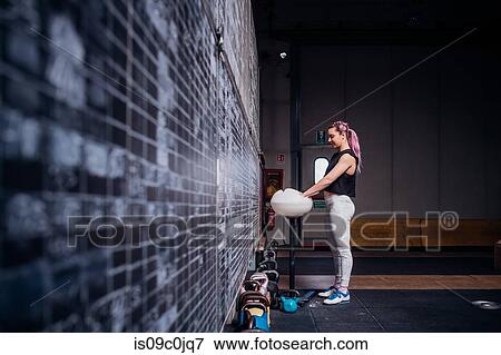 Stock Photo - Young woman powdering palms in gym. Fotosearch