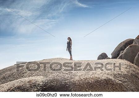 Young woman practicing yoga taking a break looking out from beach boulder, Cape Town, Western Cape, South Africa View Large Photo Image Stock Image - Young woman practicing yoga taking a break looking out from beach boulder, Cape Town, Western Cape, South Africa. Fotosearch