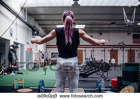 Young woman preparing to lift barbell in gym View Large Photo Image Stock Photo - Young woman preparing to lift barbell in gym. Fotosearch