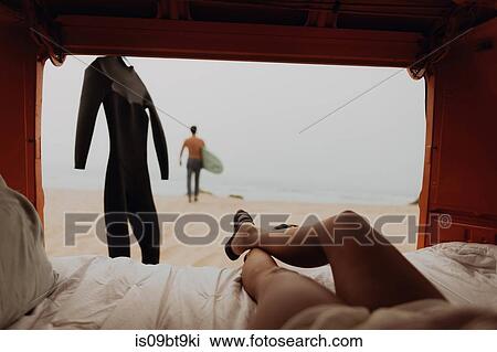 Young woman reclining in back of recreational vehicle watching surfer boyfriend on beach, Jalama, Ventura, California, USA View Large Photo Image Stock Image - Young woman reclining in back of recreational vehicle watching surfer boyfriend on beach, Jalama, Ventura, California, USA. Fotosearch