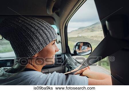 Young woman sitting in car, looking at view out of car window, Silverthorne, Colorado, USA View Large Photo Image Stock Photograph - Young woman sitting in car, looking at view out of car window, Silverthorne, Colorado, USA. Fotosearch
