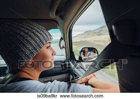 Young woman sitting in car, looking at view out of car window, Silverthorne, Colorado, USA View Large Photo Image Stock Photography - Young woman sitting in car, looking at view out of car window, Silverthorne, Colorado, USA. Fotosearch