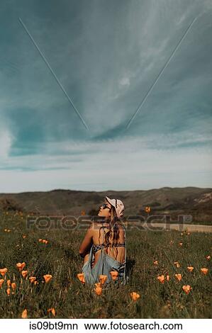 Young woman sitting in field of wildflowers looking up, Jalama, California, USA View Large Photo Image Picture - Young woman sitting in field of wildflowers looking up, Jalama, California, USA. Fotosearch