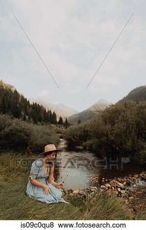 Young woman sitting picking wildflowers by rural river, Mineral King, California, USA View Large Photo Image Stock Photo - Young woman sitting picking wildflowers by rural river, Mineral King, California, USA. Fotosearch