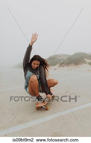 Young woman skateboarding in misty beach carpark, Jalama, California, USA View Large Photo Image Stock Image - Young woman skateboarding in misty beach carpark, Jalama, California, USA. Fotosearch