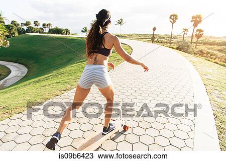 Young woman skateboarding in park, rear view, South Point Park, Miami Beach, Florida, USA View Large Photo Image Stock Image - Young woman skateboarding in park, rear view, South Point Park, Miami Beach, Florida, USA. Fotosearch