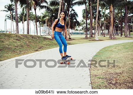 Young woman skateboarding through park, smiling, South Point Park, Miami Beach, Florida, USA View Large Photo Image Stock Image - Young woman skateboarding through park, smiling, South Point Park, Miami Beach, Florida, USA. Fotosearch