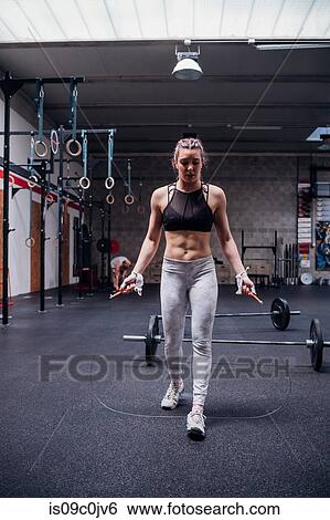 Young woman skipping in gym View Large Photo Image Stock Photograph - Young woman skipping in gym. Fotosearch