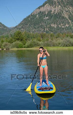 Young woman stand up paddleboarding on lake, Frisco, Colorado, USA View Large Photo Image Stock Photograph - Young woman stand up paddleboarding on lake, Frisco, Colorado, USA. Fotosearch