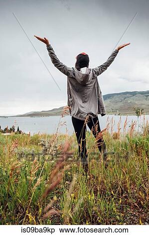Young woman standing near Dillon Reservoir, arms raised, rear view, Silverthorne, Colorado, USA View Large Photo Image Stock Photography - Young woman standing near Dillon Reservoir, arms raised, rear view, Silverthorne, Colorado, USA. Fotosearch