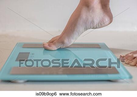 Young woman stepping onto weighing scales, close up of foot View Large Photo Image Stock Photograph - Young woman stepping onto weighing scales, close up of foot. Fotosearch