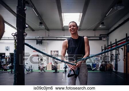 Young woman stretching arms in gym View Large Photo Image Stock Photograph - Young woman stretching arms in gym. Fotosearch