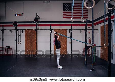 Young woman stretching arms in gym View Large Photo Image Stock Photography - Young woman stretching arms in gym. Fotosearch